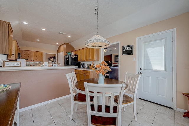 tiled dining space featuring a textured ceiling, vaulted ceiling, and ceiling fan