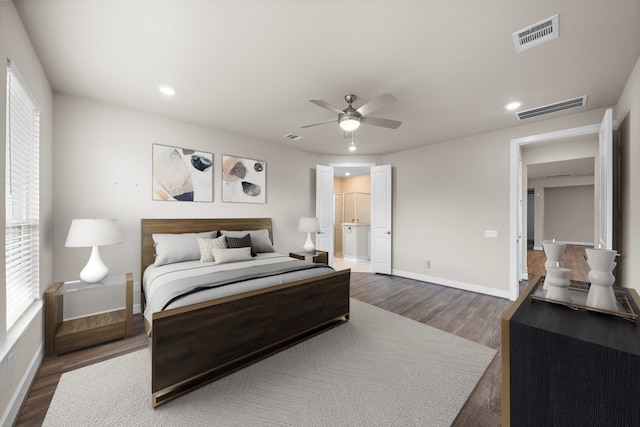 bedroom featuring ensuite bath, ceiling fan, and dark wood-type flooring