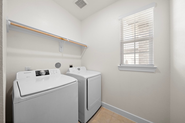 washroom featuring washing machine and clothes dryer and light tile patterned floors