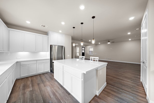 kitchen with stainless steel refrigerator, white cabinetry, ceiling fan, and dark wood-type flooring