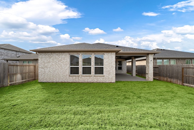 back of property with a patio area and a yard