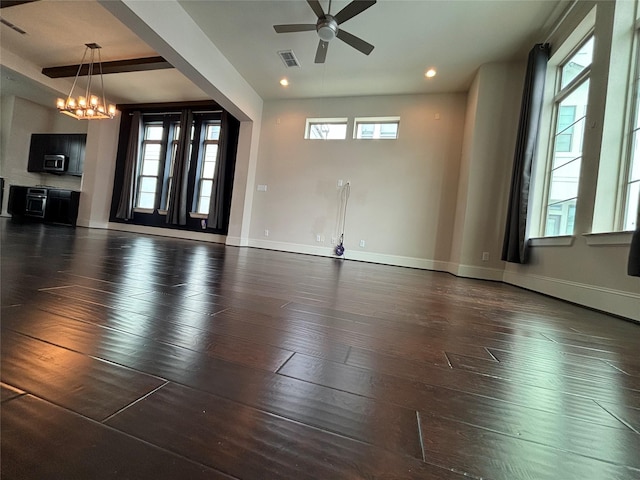 spare room with beam ceiling, dark hardwood / wood-style flooring, and ceiling fan with notable chandelier