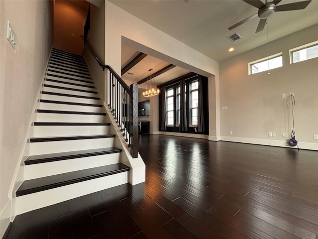 interior space with ceiling fan with notable chandelier and dark wood-type flooring