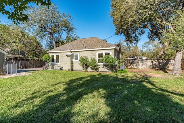 back of house featuring a lawn