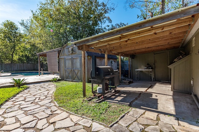 exterior space featuring a patio area, a fenced in pool, and a shed