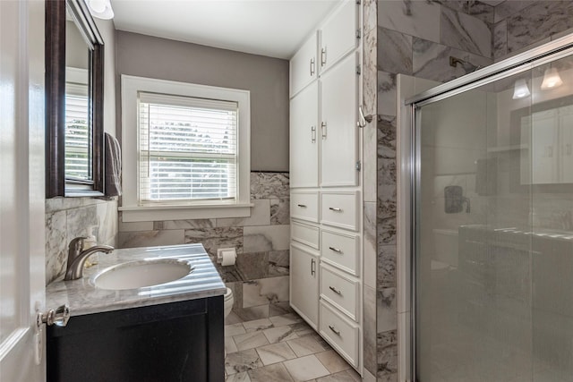 bathroom with toilet, vanity, tile walls, and walk in shower