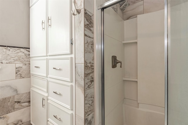 bathroom with a shower with door and tile walls