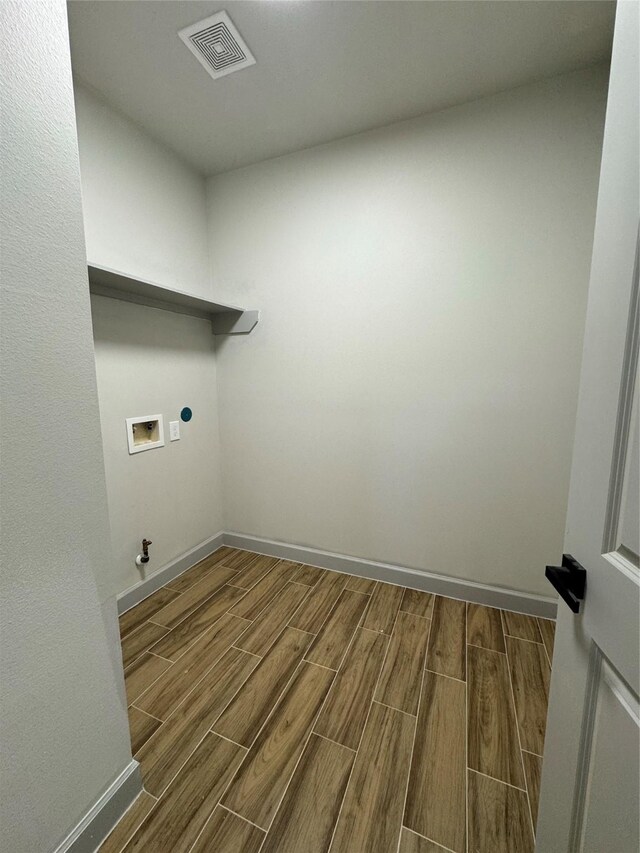 laundry room featuring electric dryer hookup, hookup for a gas dryer, hardwood / wood-style floors, and washer hookup