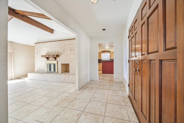 hall featuring vaulted ceiling with beams, light tile patterned floors, and a textured ceiling