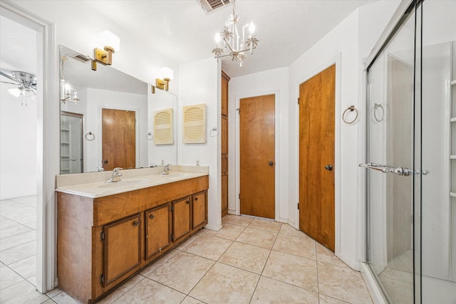 bathroom featuring vanity, ceiling fan with notable chandelier, a shower with door, and tile patterned flooring