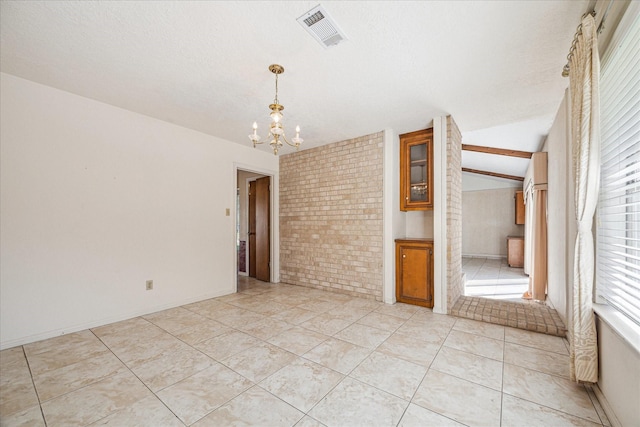 tiled empty room with brick wall, a chandelier, and lofted ceiling