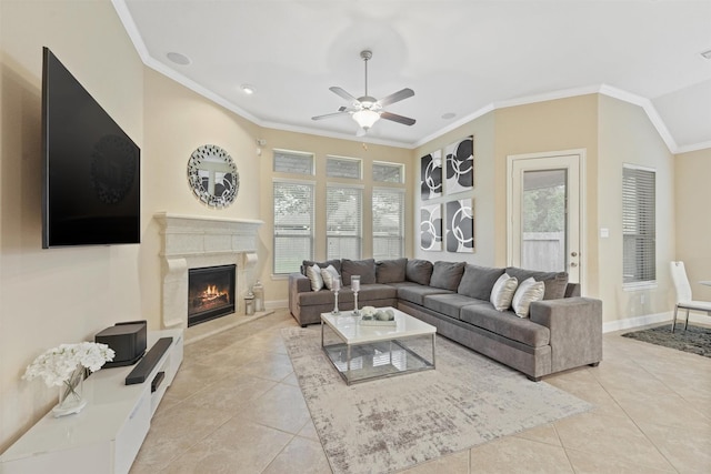 living room featuring light tile patterned floors, crown molding, a premium fireplace, and ceiling fan