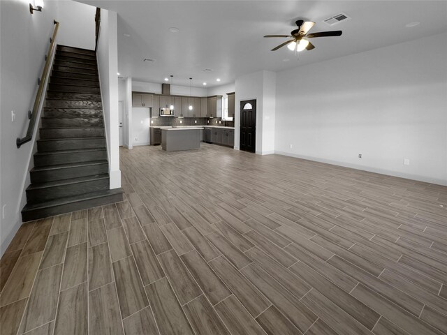 unfurnished living room with hardwood / wood-style floors and ceiling fan