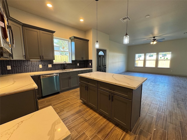 kitchen featuring stainless steel dishwasher, ceiling fan, sink, decorative light fixtures, and hardwood / wood-style floors