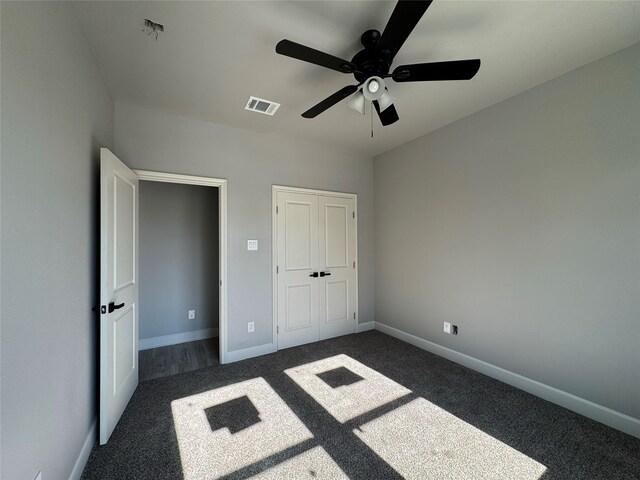 unfurnished bedroom featuring ceiling fan and dark colored carpet