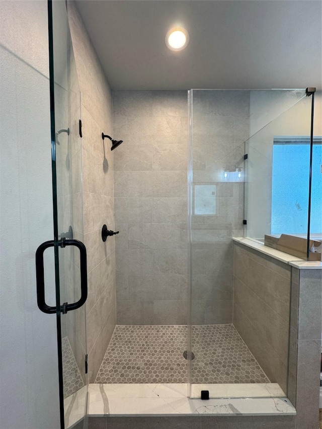 bathroom with a shower with door