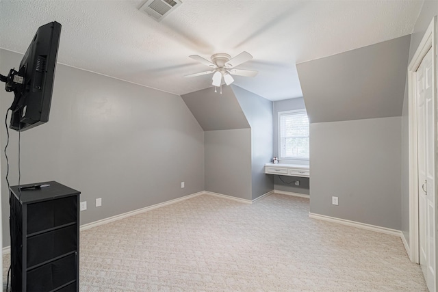 bonus room featuring a textured ceiling, ceiling fan, light carpet, and vaulted ceiling