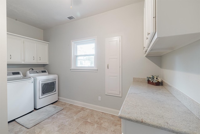 clothes washing area featuring cabinets and washing machine and dryer