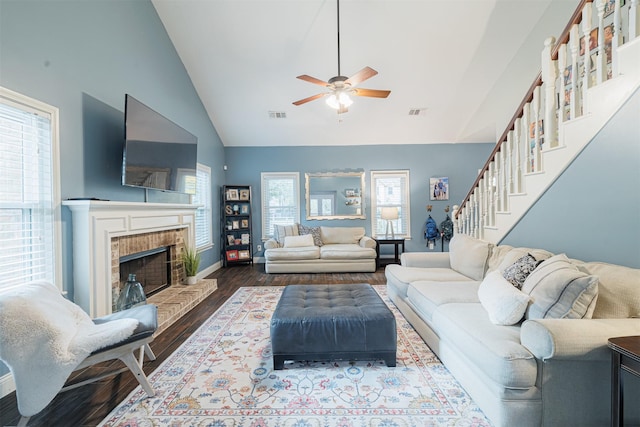 living room featuring a fireplace, hardwood / wood-style flooring, high vaulted ceiling, and ceiling fan