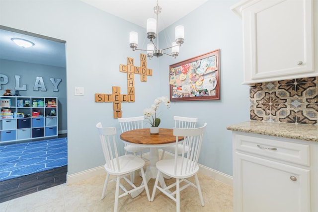 dining space with light hardwood / wood-style floors and an inviting chandelier