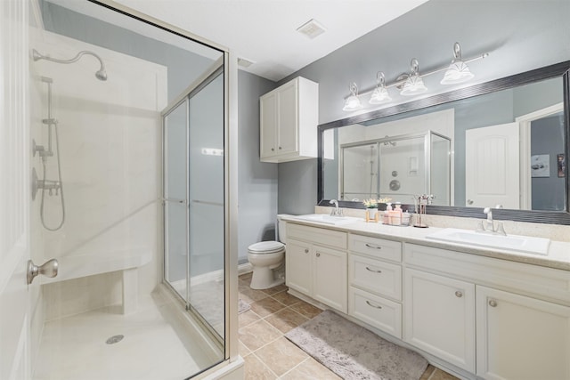 bathroom with tile patterned flooring, vanity, toilet, and a shower with door