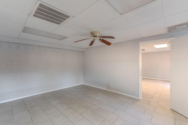 empty room featuring a drop ceiling and ceiling fan