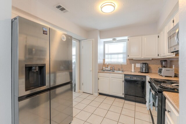 kitchen featuring white cabinets, sink, backsplash, and black appliances