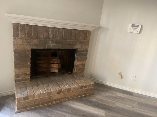 details featuring hardwood / wood-style flooring and a brick fireplace