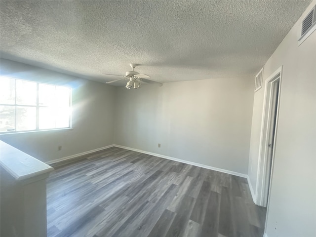 spare room featuring a textured ceiling, dark hardwood / wood-style floors, and ceiling fan