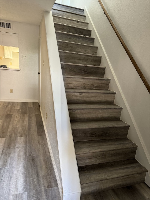 stairs featuring wood-type flooring