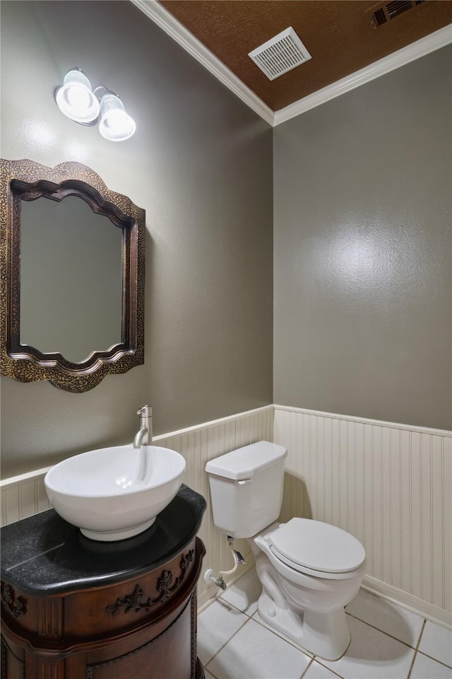 bathroom with vanity, tile patterned flooring, toilet, ornamental molding, and a textured ceiling