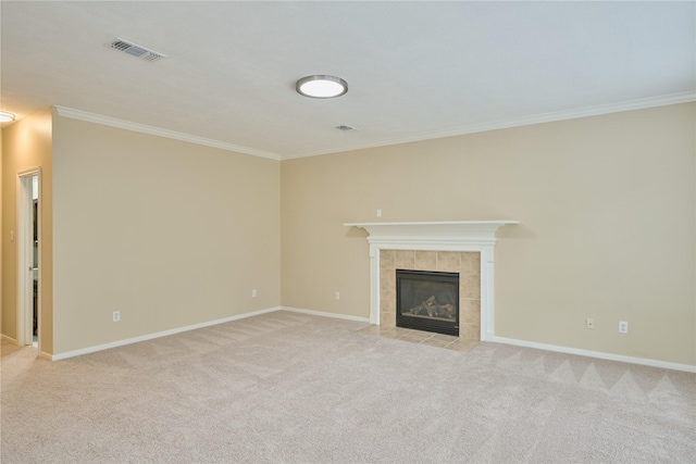 unfurnished living room with light colored carpet, ornamental molding, and a tiled fireplace