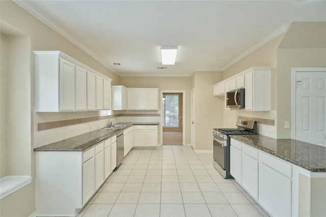 kitchen with white cabinetry, sink, stainless steel appliances, dark stone countertops, and crown molding