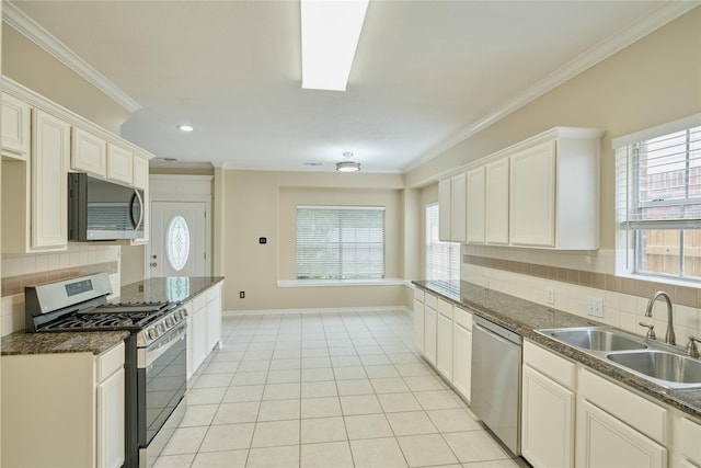 kitchen with appliances with stainless steel finishes, tasteful backsplash, crown molding, sink, and white cabinets