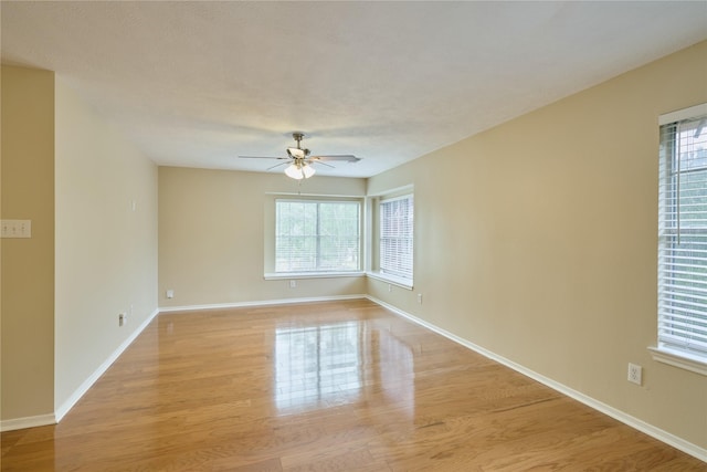 empty room featuring light wood-type flooring, plenty of natural light, and ceiling fan