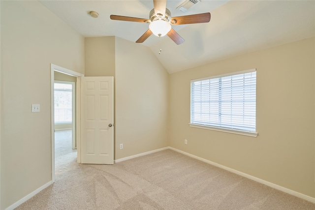 carpeted empty room featuring plenty of natural light, ceiling fan, and vaulted ceiling