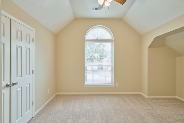 empty room with ceiling fan, light colored carpet, and lofted ceiling