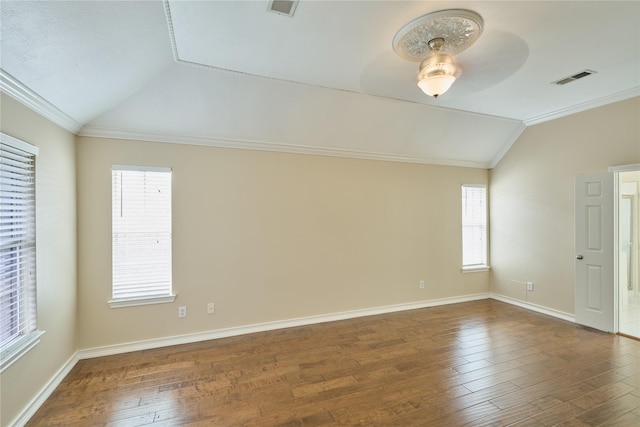 empty room with ornamental molding, dark wood-type flooring, a wealth of natural light, and lofted ceiling