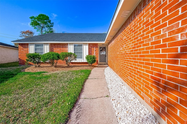 view of exterior entry with a lawn