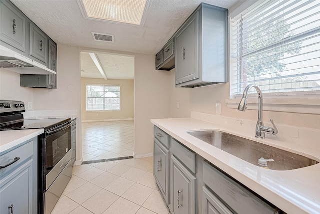 kitchen featuring ventilation hood, electric stove, sink, gray cabinets, and light tile patterned floors