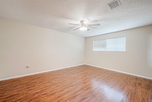 spare room featuring hardwood / wood-style floors, ceiling fan, and a textured ceiling