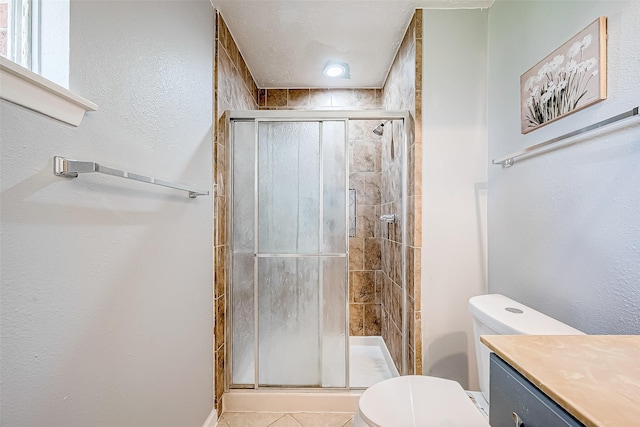 bathroom featuring walk in shower, tile patterned flooring, vanity, and toilet