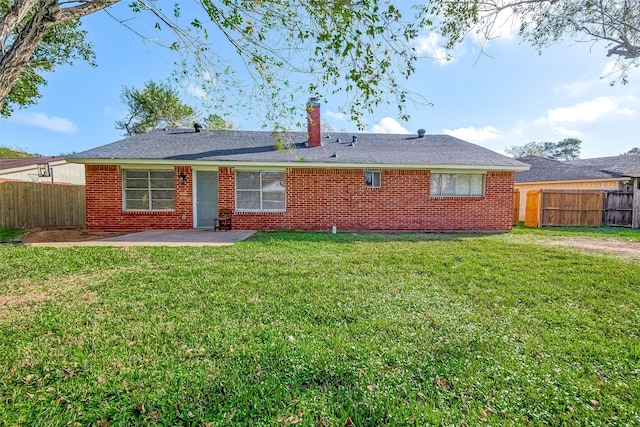 rear view of property featuring a yard and a patio area