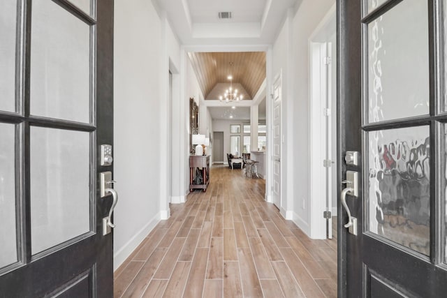 foyer with wood ceiling, light wood-type flooring, vaulted ceiling, and an inviting chandelier