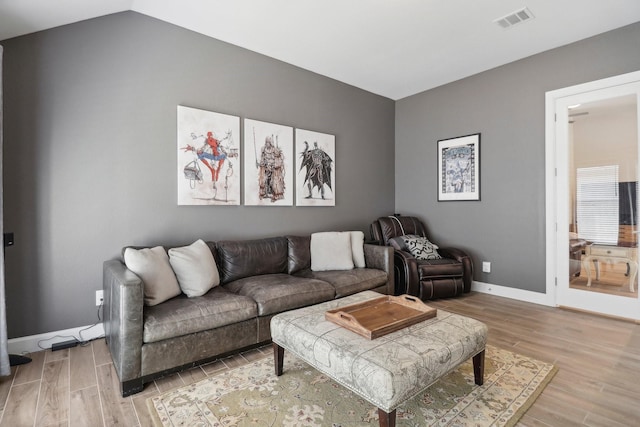 living room with hardwood / wood-style floors and vaulted ceiling