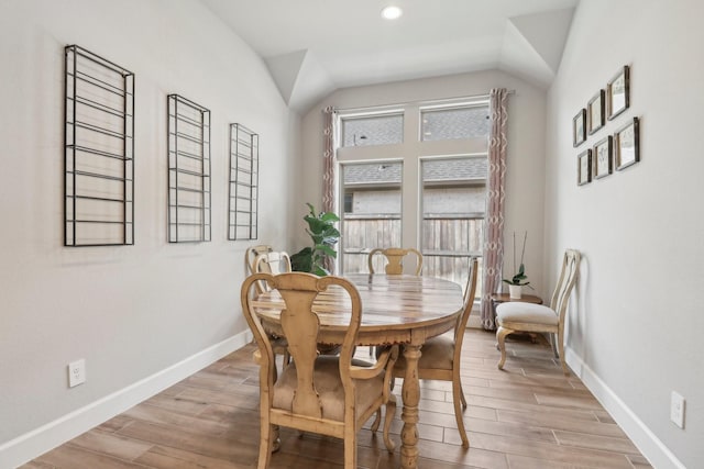 dining area featuring vaulted ceiling and light hardwood / wood-style flooring