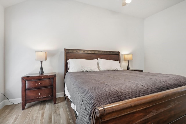 bedroom with wood-type flooring and vaulted ceiling