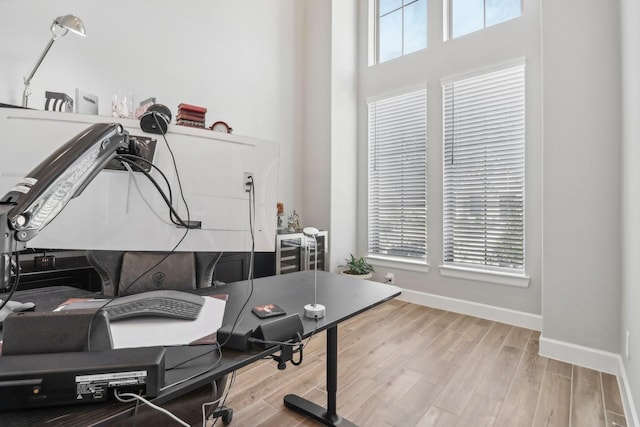 office featuring a high ceiling and light hardwood / wood-style floors