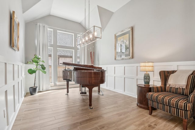 interior space with light hardwood / wood-style flooring, a chandelier, and lofted ceiling