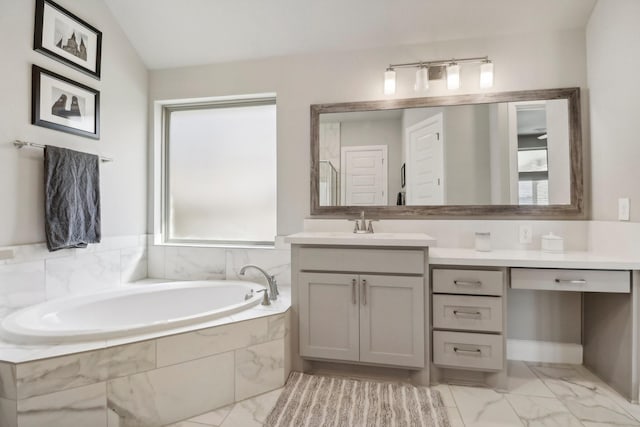 bathroom featuring vanity, a relaxing tiled tub, and lofted ceiling